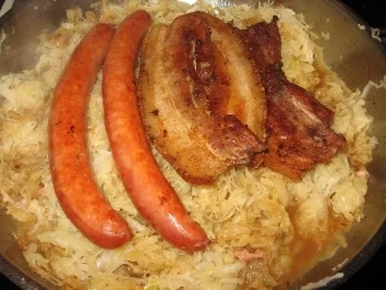 Sauerkrautgemüse mit Bauchfleisch und Mettwürstchen auf Kartoffelpüree - Rezept