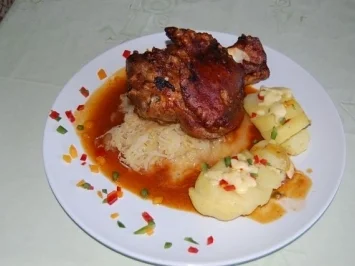 Gegrillte Schweinshaxe auf Sauerkraut mit Schmelzkartoffeln und Krautsalat - Rezept