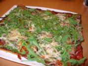 Pizza mit Rucola, Parmesan und Parmaschinken - Rezept