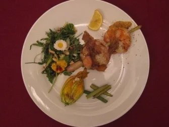 Rezept: Badierte Garnelen an gefüllten Zucchiniblüten auf Wildkräutersalatbett Badierte Garnelen an gefüllten Zucchiniblüten auf Wildkräutersalatbett - Rezept