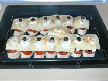 Pizzabrot mit Tomaten, Oliven und Käse überbacken - Rezept