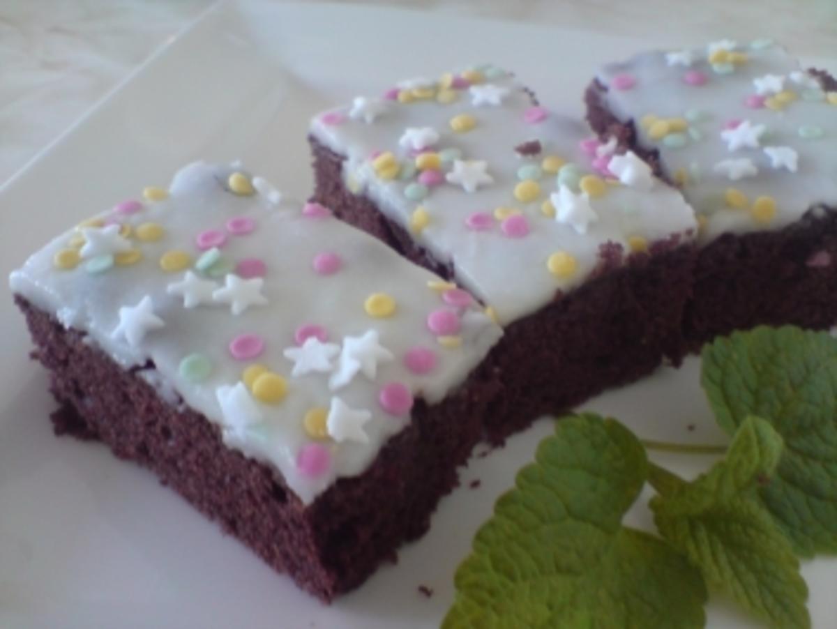 Schokoladenkuchen mit weißen Guss und bunten Streuseln - Rezept