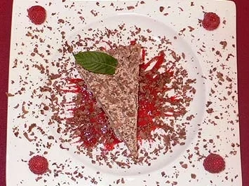 Rezept: Eistorte auf Himbeerspiegel mit Schokoraspeln und Minzblatt Eistorte auf Himbeerspiegel mit Schokoraspeln und Minzblatt - Rezept