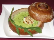 Samtsuppe von Rucola mit Pinienkernen im Brotlaib - Rezept