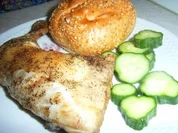 Hähnchenkeule in schwarzer Lackkorsage an Sesambrötchen und Gurkenscheiben - Rezept