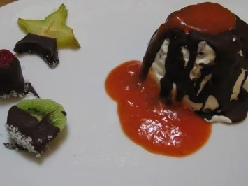 Schokokusseis mit Schokolasur auf Erdbeerspiegel an schokomelierten Früchten - Rezept