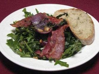 Warmer Rucolasalat mit karamellisierten roten Zwiebeln und Pinienkernen - Rezept