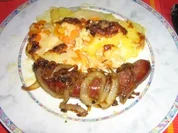 Bauernbratwurst mit Zwiebeln an Kartoffel-Karotten-Kohlrabigratin - Rezept