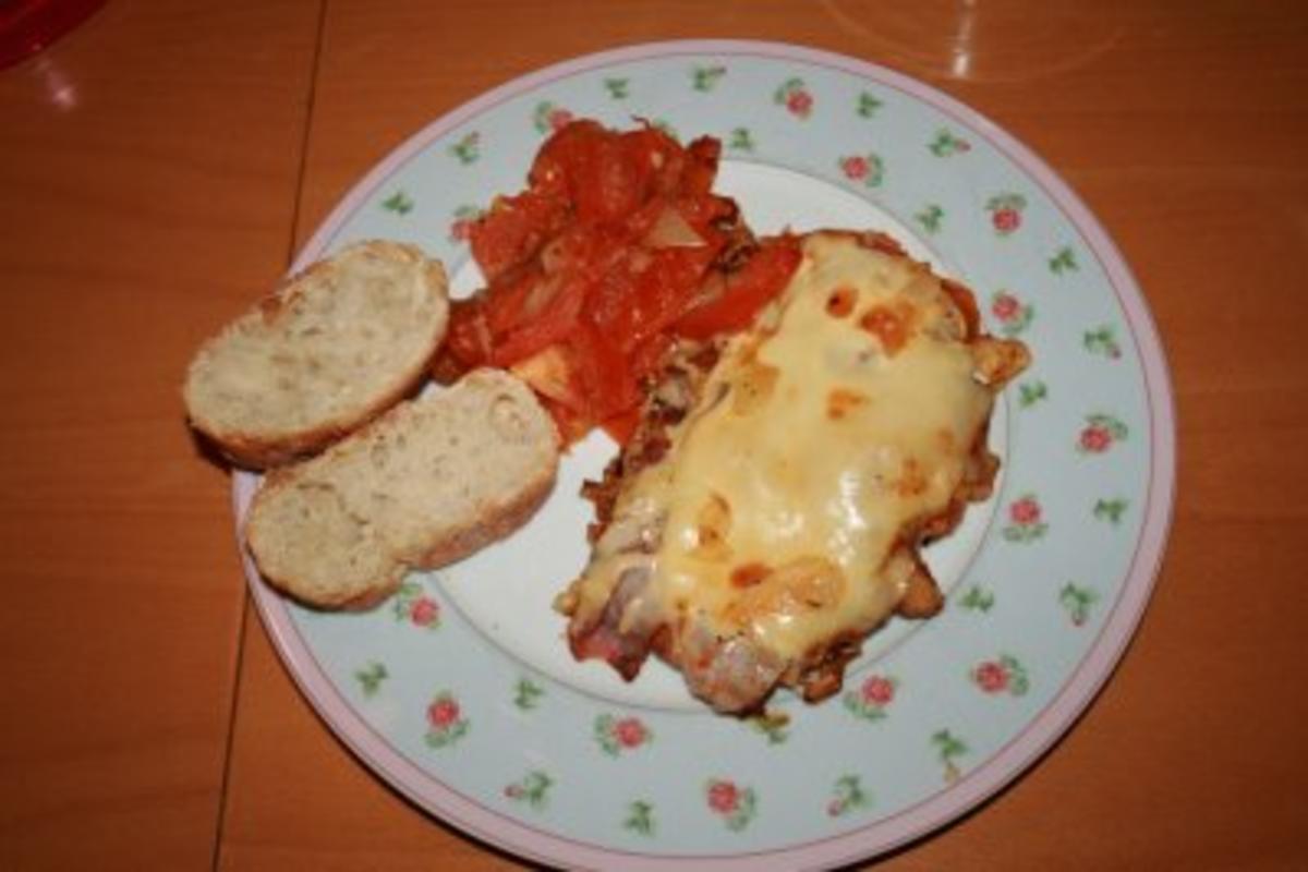 Schnitzel mit Parmaschinken und zerlaufenem Käse an Tomaten - Rezept