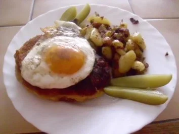 verstecktes Kotelett unterem Spiegelei mit Bratkartoffeln - Rezept