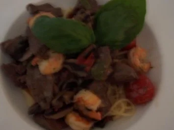 Rezept: Geschnezeltes vom Rind mit Garnelen und Kirschtomaten auf einem Nest von Tagiatelle Geschnezeltes vom Rind mit Garnelen und Kirschtomaten auf einem Nest von Tagiatelle - Rezept