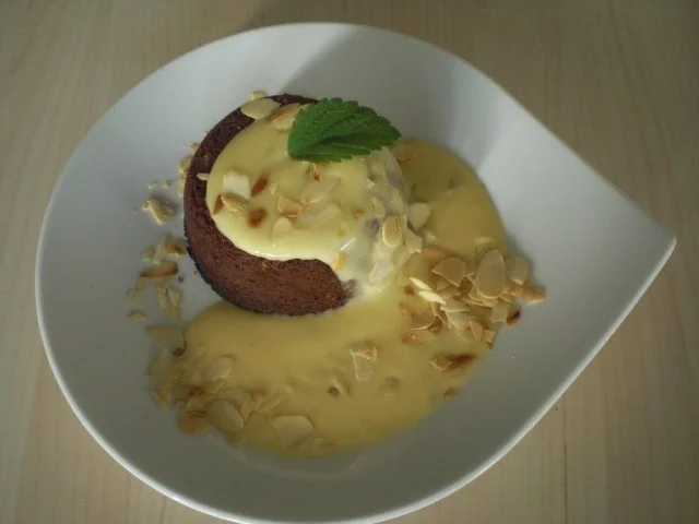 Flüssiger Schokoladenkuchen mit Mandeln an Orangen-Melissen-Sauce - Rezept