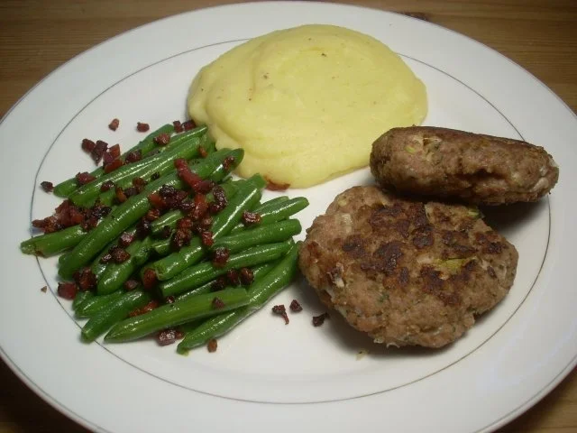 Faschierte Laibchen mit Kartoffelpüree und Speckfisolen - Rezept