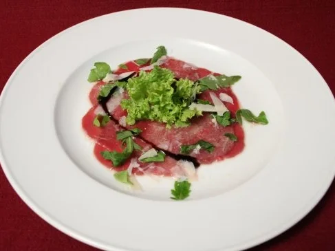 Rezept: Carpaccio vom Feldreh mit Parmesan, Rucola und Zitronenvinaigrette Carpaccio vom Feldreh mit Parmesan, Rucola und Zitronenvinaigrette - Rezept