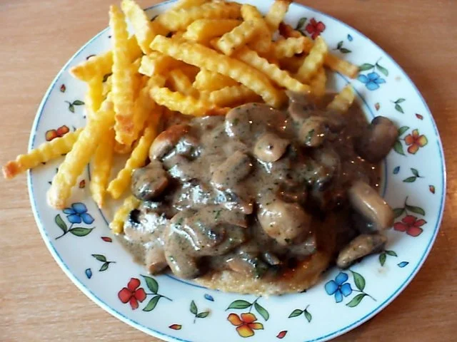 Kotelett unter einer Champignonhaube mit frischen Champignons - Rezept