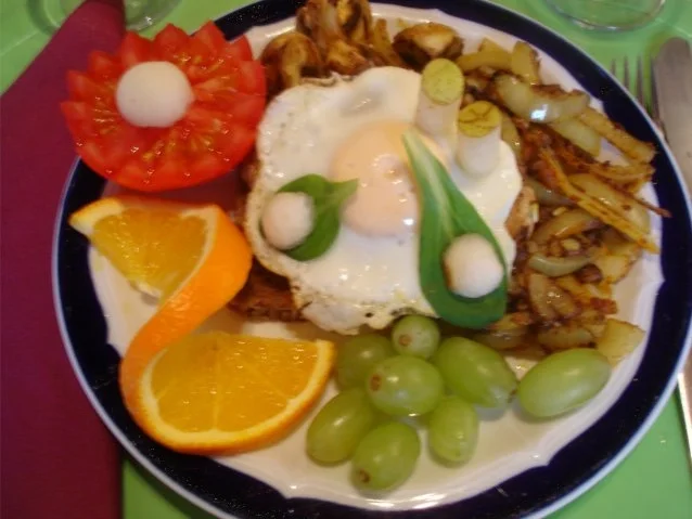 Lummerkotelett auf Vollkornbrot mit Spiegelei und Beilagen - Rezept