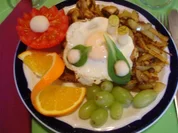 Lummerkotelett auf Vollkornbrot mit Spiegelei und Beilagen - Rezept