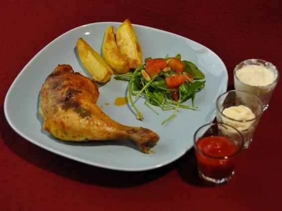 Hähnchenschenkel auf Rucola mit Kartoffelspalten - Rezept