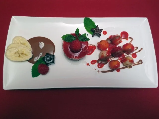 Himbeer-Kokos-Törtchen mit frischen Früchten auf Schokoladenspiegel - Rezept