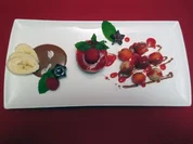 Himbeer-Kokos-Törtchen mit frischen Früchten auf Schokoladenspiegel - Rezept