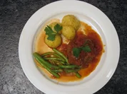 Lammbraten mit Tomaten und Zwiebeln, dazu Kartoffeln und Bohnen - Rezept