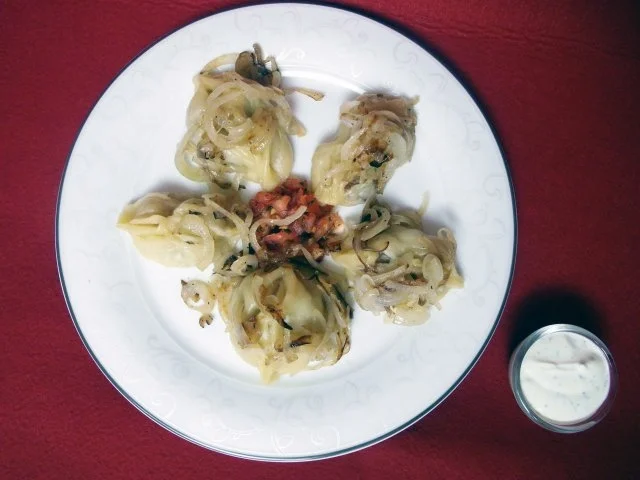 Manti mit gebratenen Zwiebelringen und verschiedenen Soßen - Rezept