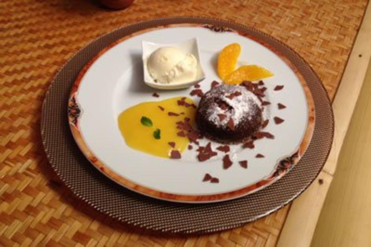 Schokoladenküchlein mit flüssigem Kern auf einem Fruchtspiegel und Eis ... Schokoladenküchlein mit flüssigem Kern auf einem Fruchtspiegel und Eis ...