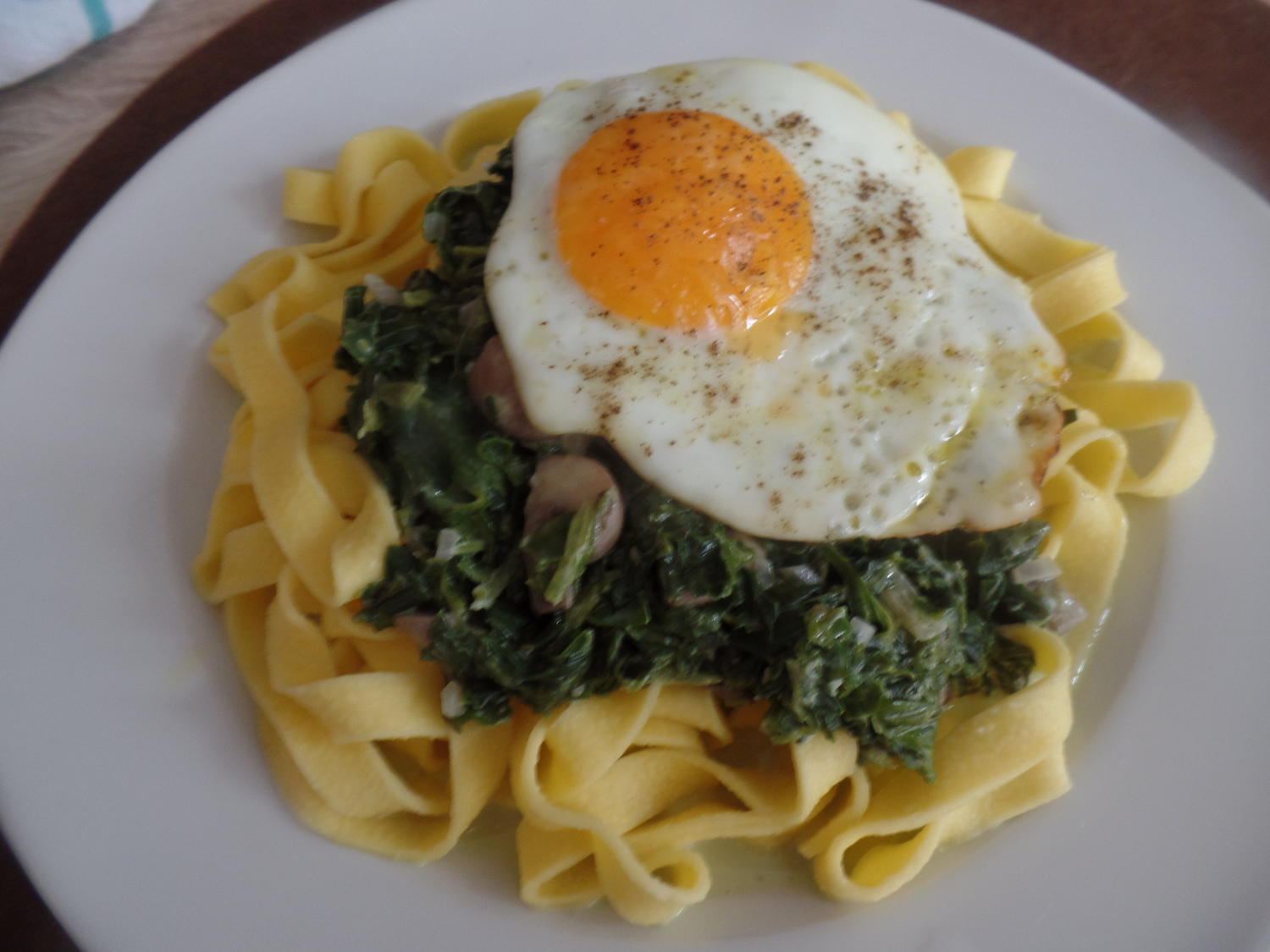 Bandnudeln mit Champigons Spinat Frischkäsesauce und Spiegeleiern