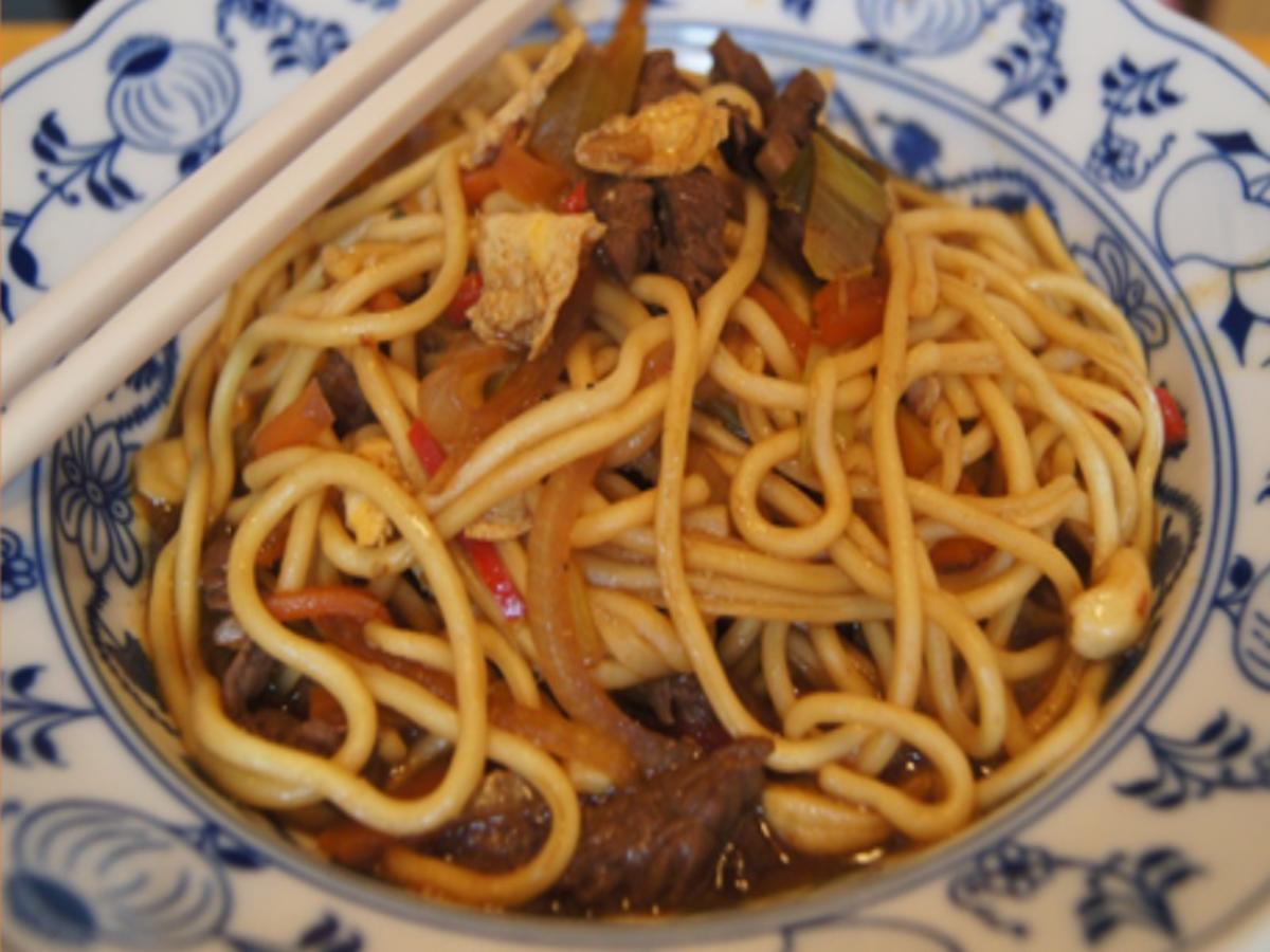 Mie-Nudeln mit Rindfleisch, Ei, Gemüse und Cashew-Nüssen im Wok ...