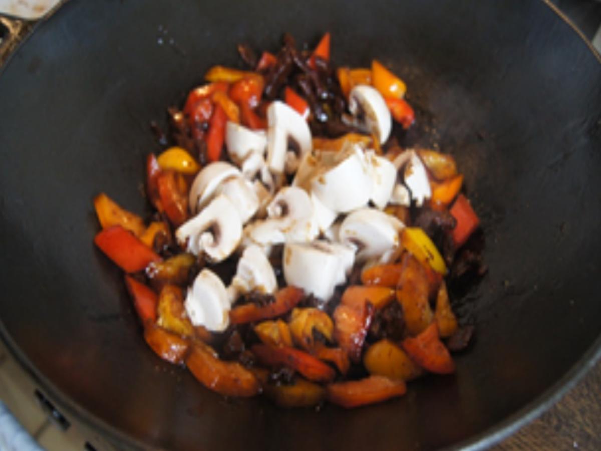 Putenschnitzel, Paprikamix und Champignons im Wok mit gelben ...