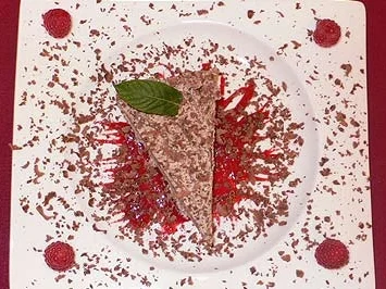 Eistorte auf Himbeerspiegel mit Schokoraspeln und Minzblatt - Rezept