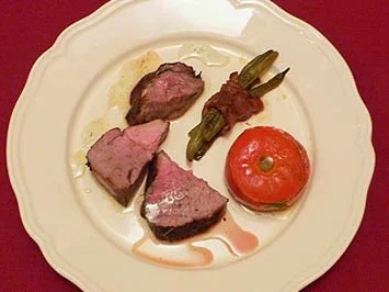 Milchlammkeule an gefüllten Tomaten und Speckböhnchen (Corderito lechal) - Rezept