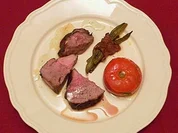 Milchlammkeule an gefüllten Tomaten und Speckböhnchen (Corderito lechal) - Rezept