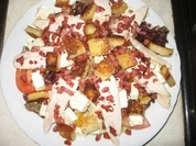 Eichblattsalat auf Orangendressing mit gegarter Hühnerbrust, Coutons, Feta und Speckwürfeln - Rezept