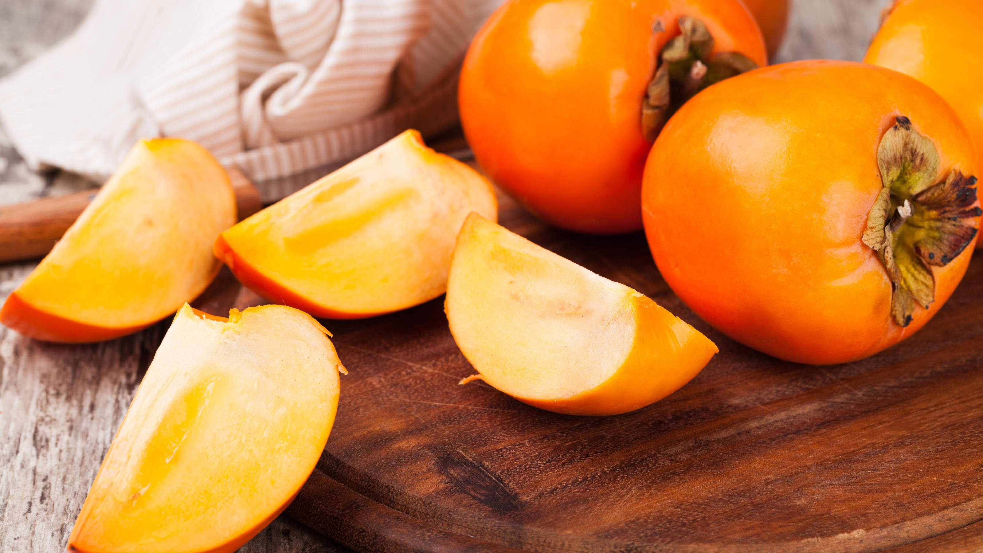 Kiwis mit Schale essen – geht das? Kakis werden wegen ihres Aussehens auch orangefarbene Tomaten genannt.
