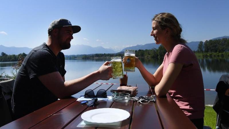 Radler im Öko-Test: 18 Biermischgetränke schneiden „gut“ ab Ein Paar genießt ein gemeinsames Bier in der Sonne in einem Biergarten