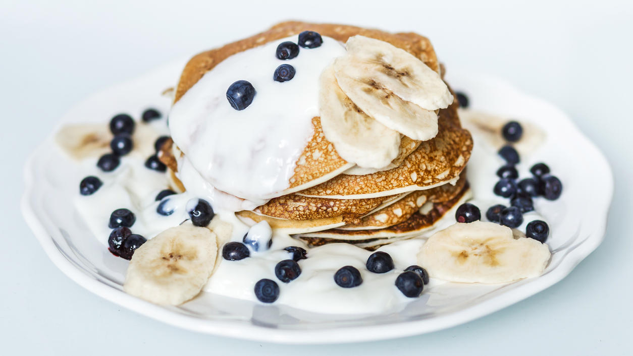 Diese Pfannkuchen werden dank Geheimzutat ganz besonders fluffig Hausgemachte Pfannkuchen mit Banane, Heidelbeeren und Sauerrahm