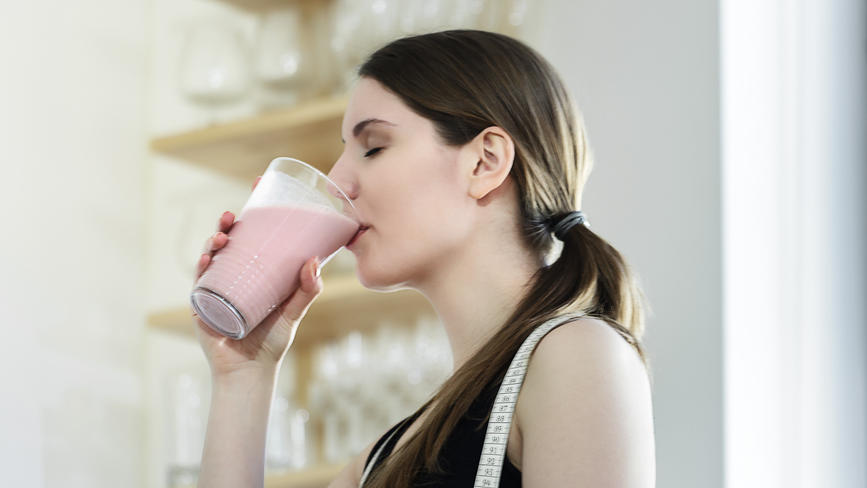 Frau trinkt Proteinshake während der Diät