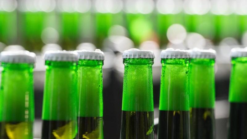 Radler im Öko-Test: 18 Biermischgetränke schneiden „gut“ ab Flaschen mit Bio-Bier auf einem Förderband
